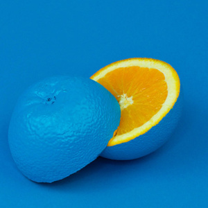 Naranja pintada de azul cortada por la mitad
